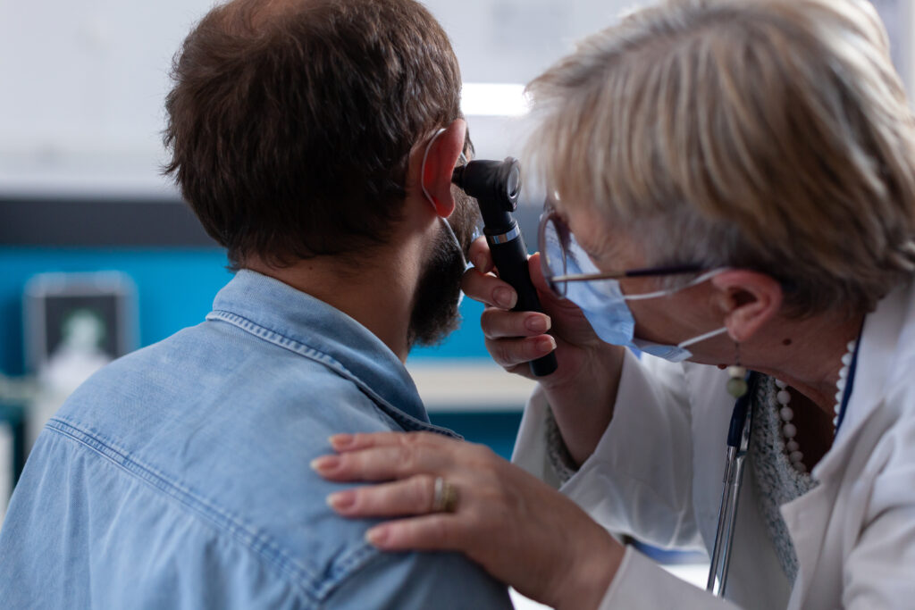 Close up of specialist using otoscope to do ear examination with patient - Dr. Manasi Mehra